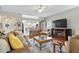 Bright living room with wood floors, ceiling fan, and an open layout leading to the kitchen at 3584 Tropical Seas Loop, Tavares, FL 32778