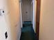 Hallway with doors leading to other rooms and green carpet at 37 N Normandale Ave, Orlando, FL 32835