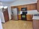 Modern kitchen with wood cabinets, stainless steel refrigerator, and updated appliances at 37 N Normandale Ave, Orlando, FL 32835