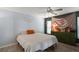 Comfortable bedroom featuring a queen-size bed, decorative tapestry, and a vintage green dresser at 38 Townhill Dr, Eustis, FL 32726