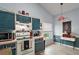 Cozy kitchen showcasing blue cabinets, a white stove, and a window bringing in natural light at 38 Townhill Dr, Eustis, FL 32726