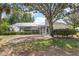 Lush backyard with mature trees, screened lanai, and well-maintained landscaping at 39206 Treeline Dr, Lady Lake, FL 32159