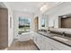 Bright bathroom featuring double vanity, soaking tub near a window offering an outdoor view at 39206 Treeline Dr, Lady Lake, FL 32159