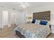 Primary bedroom with an upholstered headboard and ensuite bath entrance at 39206 Treeline Dr, Lady Lake, FL 32159
