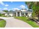 Well-maintained home with lush landscaping, a green roof, and a concrete driveway at 39206 Treeline Dr, Lady Lake, FL 32159