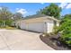Spacious three-car garage with an extended driveway and mature landscaping at 39206 Treeline Dr, Lady Lake, FL 32159
