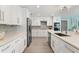 Bright kitchen features modern design with white cabinets, stone countertops, and stainless steel appliances at 39206 Treeline Dr, Lady Lake, FL 32159