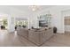 Spacious living room with a large sofa, entertainment center, and stylish decor at 39206 Treeline Dr, Lady Lake, FL 32159
