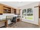 Office with custom wood cabinetry, a built-in desk, and large window for natural light at 39206 Treeline Dr, Lady Lake, FL 32159
