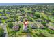 An aerial view of a community with mature trees, a golf course, and a home marked by a pin for its ideal location at 39653 Grove Hts, Lady Lake, FL 32159