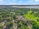 Overhead shot showcasing the community's clubhouse, pool, parking area, golf course, and lush trees with a waterway in the distance at 39653 Grove Hts, Lady Lake, FL 32159