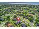 Beautiful aerial view of a residential area featuring lush greenery, a large lake, and houses with well-kept lawns at 39653 Grove Hts, Lady Lake, FL 32159