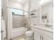 Well-lit bathroom with a bathtub, white vanity, modern fixtures, and decorative shelves at 39653 Grove Hts, Lady Lake, FL 32159