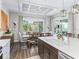 Dining area with a large window, wood table, and decorative lighting, adjacent to a modern kitchen island at 39653 Grove Hts, Lady Lake, FL 32159