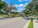 Community entrance featuring a guardhouse, palm trees, brick columns, and mature landscaping, offering a secure and welcoming entry at 39653 Grove Hts, Lady Lake, FL 32159