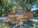 Harbor Hills entrance sign with brick details, rock waterfall, and lush greenery, creating a welcoming and grand arrival at 39653 Grove Hts, Lady Lake, FL 32159