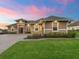 Inviting home exterior features a paver driveway, manicured lawn, and professionally designed landscaping, enhancing curb appeal at 39653 Grove Hts, Lady Lake, FL 32159