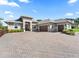 Beautiful single-story home with paver driveway, three-car garage, manicured shrubs, and neutral color scheme at 39653 Grove Hts, Lady Lake, FL 32159