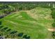 Aerial view of a well-maintained golf course with lush greenery, trees, and golfers enjoying a round on a sunny day at 39653 Grove Hts, Lady Lake, FL 32159
