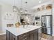 Bright kitchen featuring an island with a white countertop, stainless steel appliances, and modern lighting fixtures at 39653 Grove Hts, Lady Lake, FL 32159
