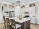 Modern kitchen boasts pendant lighting, stainless appliances, and seating around a center island at 39653 Grove Hts, Lady Lake, FL 32159