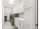 Bright laundry room with white cabinetry, modern washer and dryer, and ample counter space at 39653 Grove Hts, Lady Lake, FL 32159