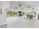 Spacious living room with large windows, fireplace, comfortable seating, and tray ceiling with multiple ceiling fans at 39653 Grove Hts, Lady Lake, FL 32159