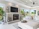 Comfortable living room with a fireplace, large windows, and backyard views at 39653 Grove Hts, Lady Lake, FL 32159