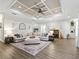 Bright living room boasts coffered ceilings, a large sectional sofa, and warm, neutral décor at 39653 Grove Hts, Lady Lake, FL 32159