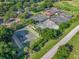 Overhead shot of community tennis courts surrounded by lush landscaping and mature trees with a golf course in the background at 39653 Grove Hts, Lady Lake, FL 32159