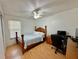 This bedroom includes a closet, ceiling fan, desk and light wood floors at 40226 Palm St, Lady Lake, FL 32159