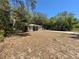 Exterior view of house with vinyl siding and black shutters, complemented by a spacious, sun-drenched front yard at 40226 Palm St, Lady Lake, FL 32159