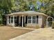 Charming home featuring vinyl siding, black shutters, and a quaint front porch with seating at 40226 Palm St, Lady Lake, FL 32159
