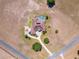Aerial view of a home with a basketball court, screened in pool, brick driveway, and lush landscaping at 41522 Saddle Ridge Ln, Weirsdale, FL 32195