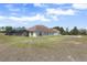 Aerial view showcasing the property's screened pool, lush landscaping, and expansive green lawn at 41522 Saddle Ridge Ln, Weirsdale, FL 32195