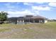 Aerial view showcasing the property's screened pool, lush landscaping, and expansive green lawn at 41522 Saddle Ridge Ln, Weirsdale, FL 32195