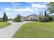 Elegant home featuring lush landscaping, a three-car garage, and a circular driveway at 41522 Saddle Ridge Ln, Weirsdale, FL 32195