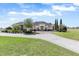 Classic home featuring lush landscaping, a three-car garage, and a circular driveway at 41522 Saddle Ridge Ln, Weirsdale, FL 32195