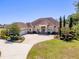 Beautiful single-story home showcasing a circular driveway, lush landscaping, and a three-car garage at 41522 Saddle Ridge Ln, Weirsdale, FL 32195