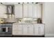 This kitchen boasts custom white cabinets, a stainless steel range, and granite countertops at 41522 Saddle Ridge Ln, Weirsdale, FL 32195