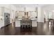 Spacious kitchen with a large island, white cabinets, stainless steel appliances, and dark wood floors at 41522 Saddle Ridge Ln, Weirsdale, FL 32195