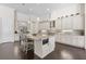 Open kitchen with island, custom white cabinets, stainless steel appliances, and granite countertops at 41522 Saddle Ridge Ln, Weirsdale, FL 32195