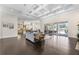 Open-concept living room featuring dark wood floors, coffered ceiling, fireplace, and view of the kitchen at 41522 Saddle Ridge Ln, Weirsdale, FL 32195