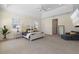 A spacious main bedroom has a sitting area, a four poster bed, and large windows to the outside at 41522 Saddle Ridge Ln, Weirsdale, FL 32195