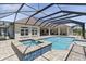 A screened pool and spa are a relaxing part of the exterior with a nice view of the home at 41522 Saddle Ridge Ln, Weirsdale, FL 32195