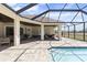 The spacious screened-in patio features exposed beams, tan brick, and comfortable seating around the pool at 41522 Saddle Ridge Ln, Weirsdale, FL 32195