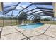 A stunning screened-in pool with a hot tub and brick surround provides a relaxing outdoor experience at 41522 Saddle Ridge Ln, Weirsdale, FL 32195
