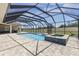 A beautiful screened pool with a spa sits near a large open backyard under a blue partly cloudy sky at 41522 Saddle Ridge Ln, Weirsdale, FL 32195