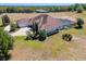 An estate showcasing a beautiful home with a screened-in pool, lush landscaping and brick driveway at 41522 Saddle Ridge Ln, Weirsdale, FL 32195