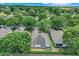 Aerial scene of a residential area featuring cozy homes surrounded by lush greenery and tall trees at 4167 Capland Ave, Clermont, FL 34711